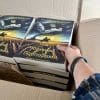 a hand reaching into a box of books under black banners