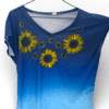 Blue gradient V-neck T-shirt with yellow sunflower embroidery on the front, hanging on a hanger.