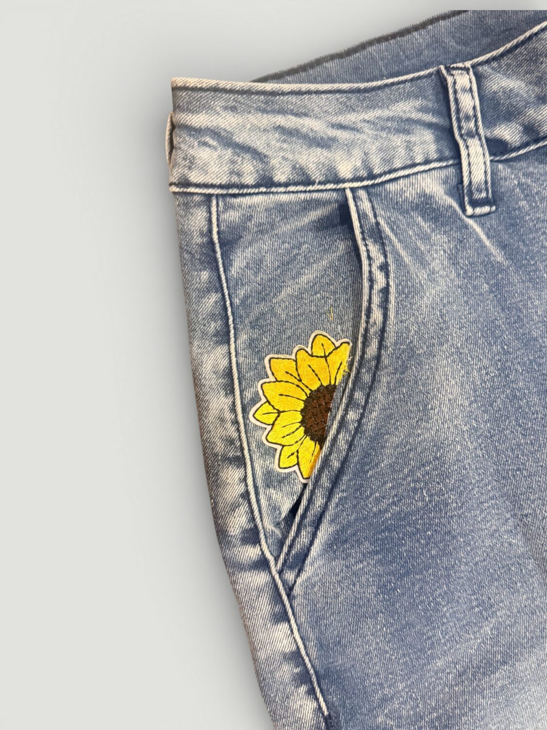 IMG_8029 17 Blue denim jeans with a yellow sunflower embroidery on the front pocket area.