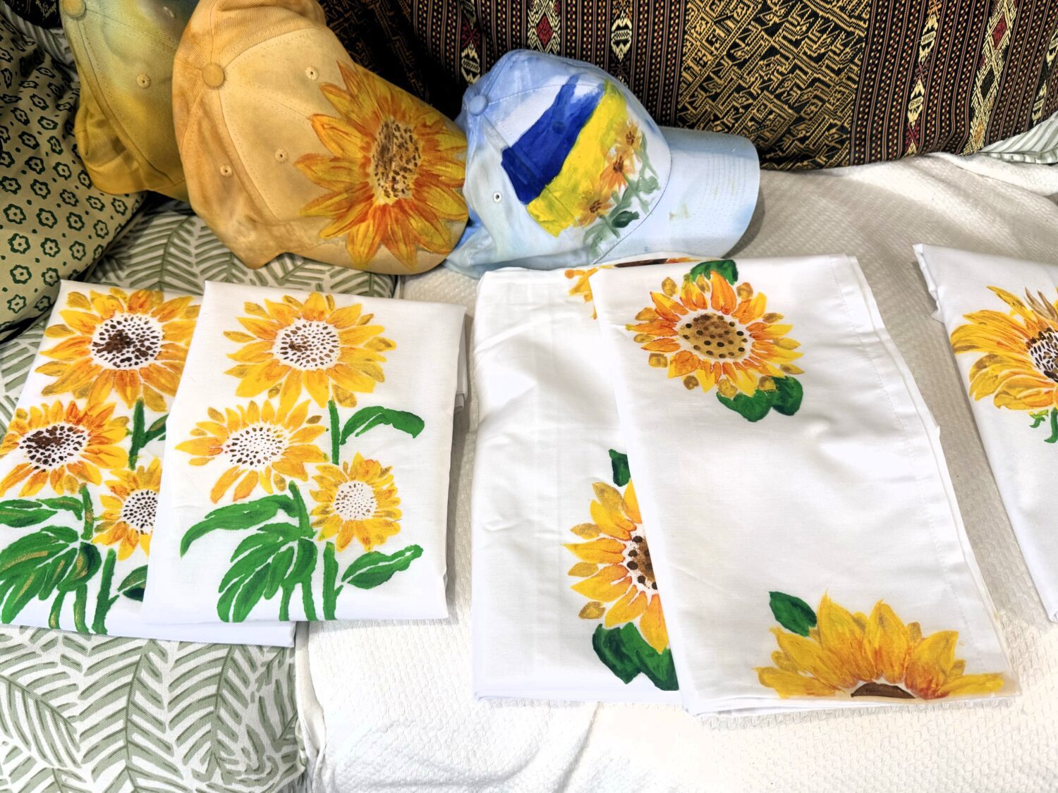 IMG_3001 White fabric napkins with bright yellow sunflower prints laid on a couch.