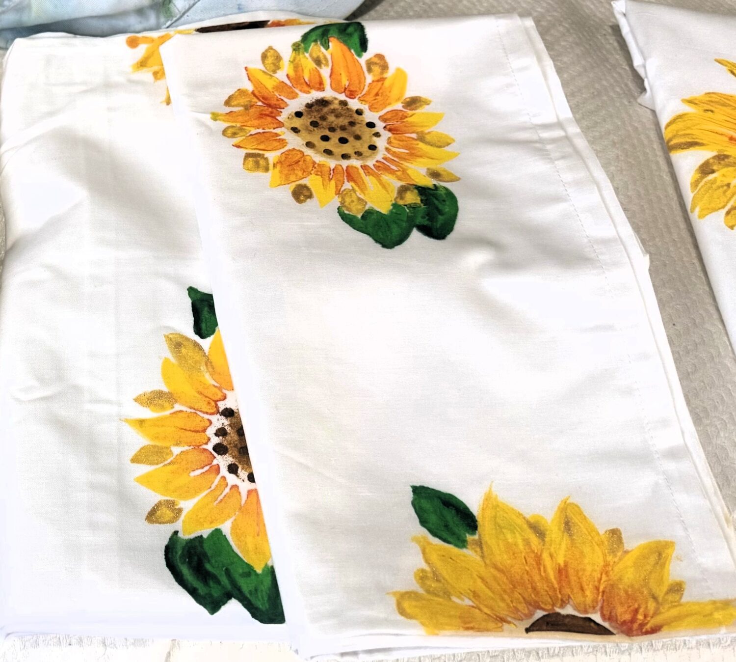 IMG_3001a White fabric napkins with bright sunflower prints scattered around.