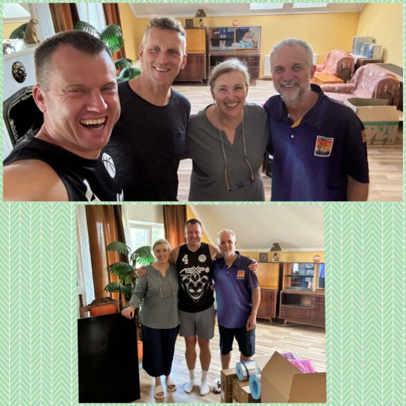 Four adults smiling for a casual indoor group photo in a sunny living room with plants and vintage furniture in the background.